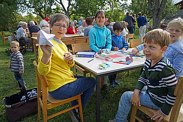 Springfrösche und Papiermonsterchen werden gefaltet. Die Kinder staunen.
