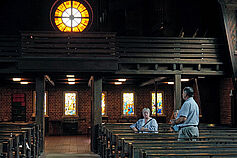 Blick in Richtung des abtrennbaren Gemeinderaumes unter der Empore und auf das Bartningsche Rundfenster.